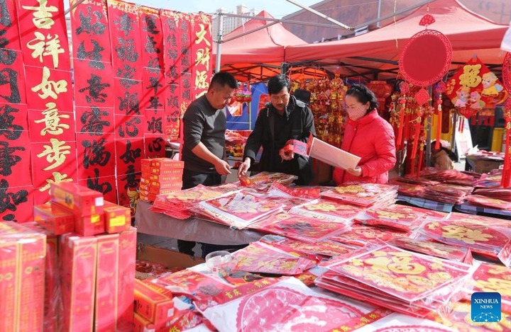 Mua sắm đồ trang trí Tết Nguyên đán tại một khu chợ thành phố Đinh Tây, tỉnh Cam Túc.