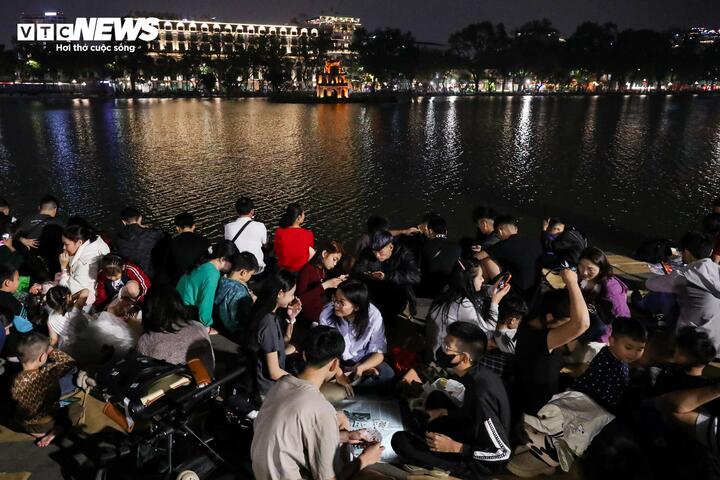 Càng gần thời khắc giao thừa, lượng người đổ về khu vực quanh Hồ Gươm càng tăng, không khí trở nên đông đúc hơn.