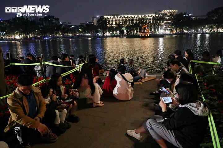 Để thưởng thức màn pháo hoa chào mừng năm mới, nhiều người dân đã có mặt từ sớm, chọn những vị trí đẹp quanh khu vực hồ Gươm để theo dõi.