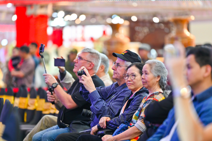 Khách quốc tế chăm chú xem các tiết mục biểu diễn trong buổi tổng duyệt bế mạc Hội chợ Mùa Xuân.