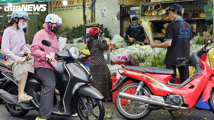 Người dân đi chợ mua hoa tươi ngày mùng 2 Tết.