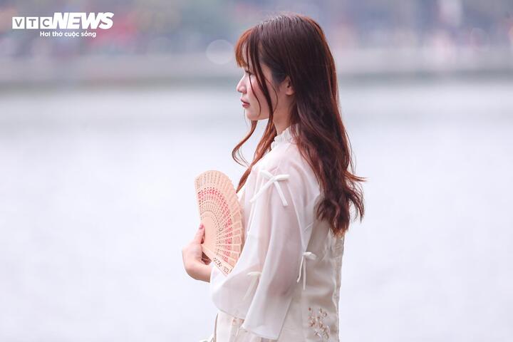 Nhiều thiếu nữ Hà Nội diện áo dài, thướt tha dạo quanh hồ Gươm, lưu lại hình ảnh duyên dáng bên sắc hoa đào.