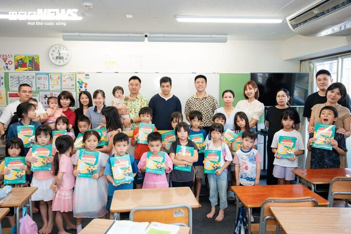 Phụ huynh và các em học sinh lớp “Tiếng Việt của em” nhận sách "Vui học tiếng Việt". (Ảnh: Duy Hùng)