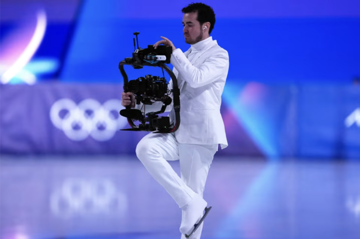 Jordan Cowan quay phim trong bộ đồ trắng trên sân băng. (Nguồn: CNN)