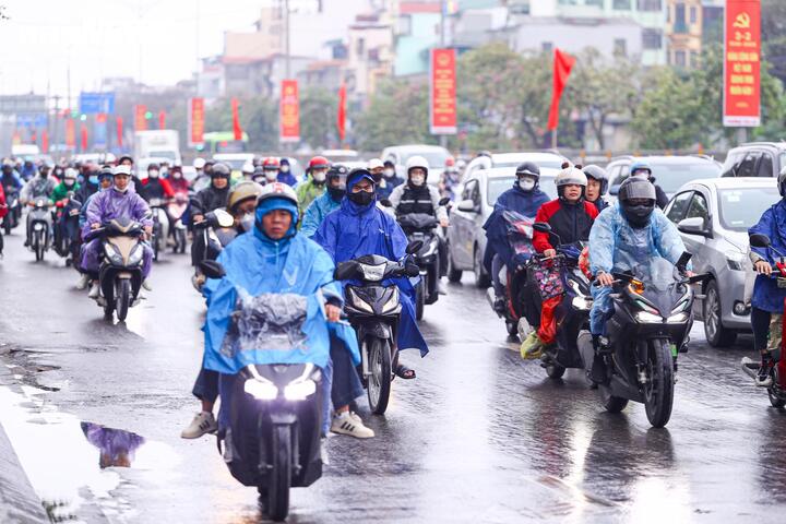 Trong cơn mưa phùn kéo dài, việc đi lại của người dân càng thêm vất vả, nhiều phương tiện phải di chuyển chậm để đảm bảo an toàn.