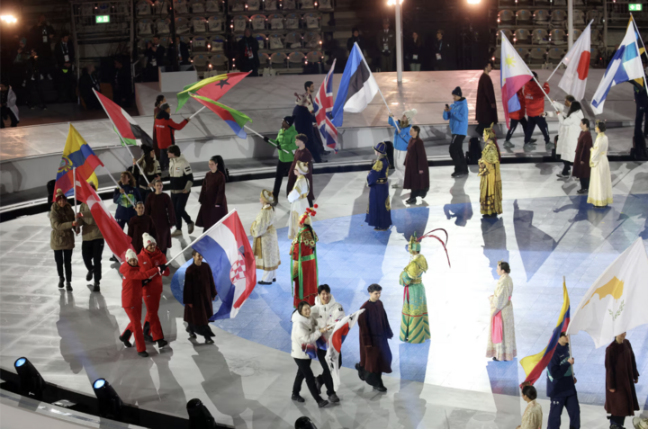 Các VĐV cầm cờ dẫn đầu đoàn diễu hành trong lễ bế mạc.