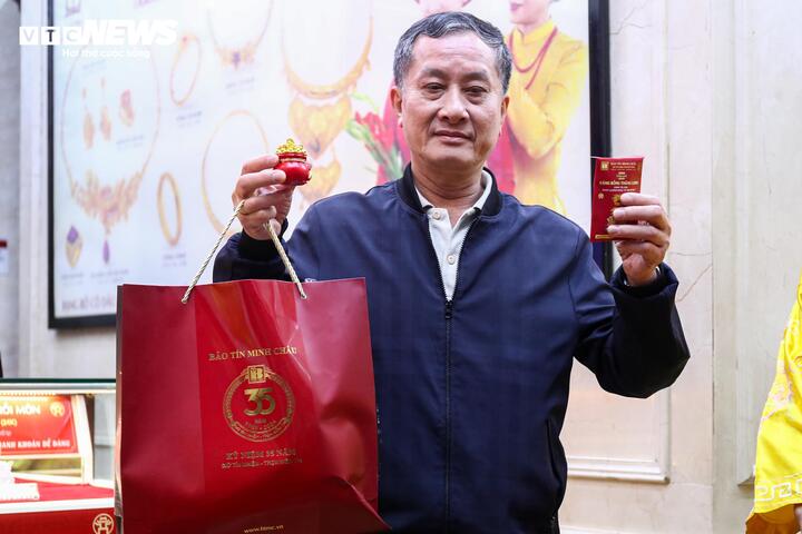 Tại Bảo Tín Minh Châu, ông Tô Hòa Bình vui mừng vì sau nhiều giờ chờ đợi đã trở thành người đầu tiên mua được vàng trong ngày vía thần Tài.