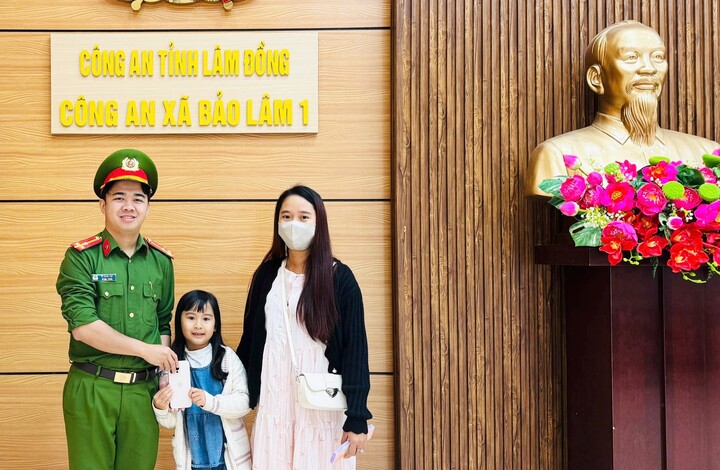 Cháu Thục Anh trao chiếc điện thoại nhặt được cho các chú công an và nhờ trả lại cho người đánh rơi. Ảnh: Công an cung cấp