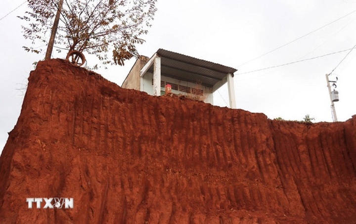 Việc hạ cốt nền trong quá trình thi công mở rộng tuyến đường ĐT.753 khiến nhiều nhà dân nằm cheo leo trên độ cao từ 8-9m. (Ảnh: Đậu Tất Thành/TTXVN)