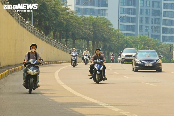 Trưa nay nhiệt độ Hà Nội tăng lên 29°C, nhiều người mặc áo ngắn tay, áo chống nắng khi ra đường. (Ảnh: Minh Quang)