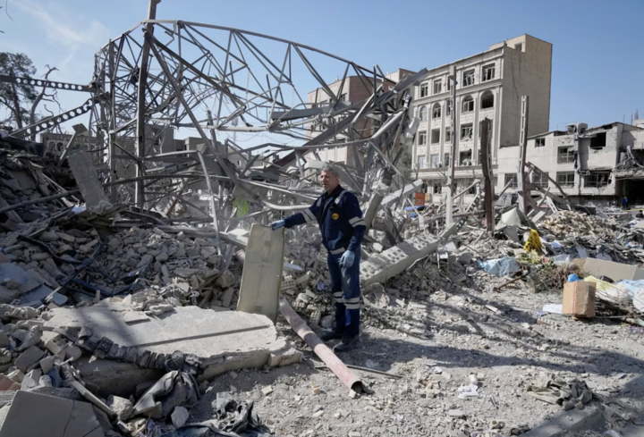 Công nhân điện lực kiểm tra đống đổ nát sau cuộc tấn công của Mỹ và Israel. (Ảnh: AP)