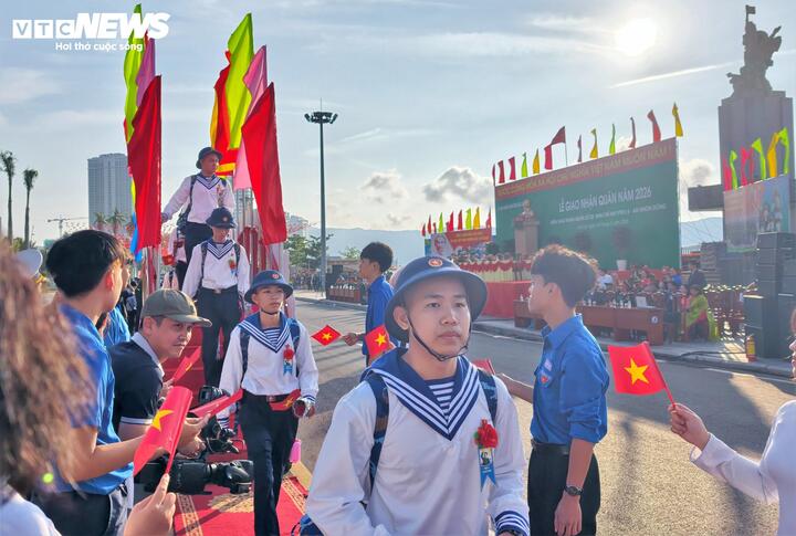 Giữa sắc đỏ của cờ Tổ quốc và tiếng trống hội rộn rã, hình ảnh những chàng trai mười tám, đôi mươi trong bộ quân phục còn thơm mùi vải mới, đội mũ vây sao sáng rực, đã tạo nên một bức tranh nhiệt huyết, tươi trẻ.