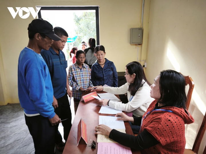 Cử tri được thành viên tổ phục vụ bầu cử hướng dẫn quy trình.