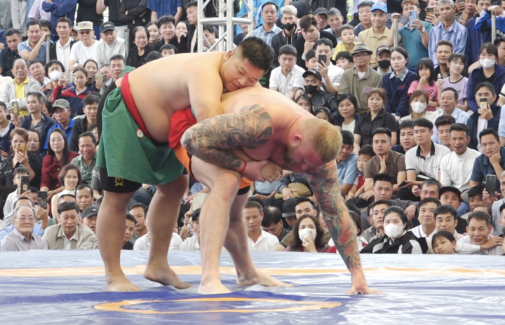 Đô vật Nguyễn Thế Cử luồn ra phía sau, kiểm soát phần lưng của Alex.