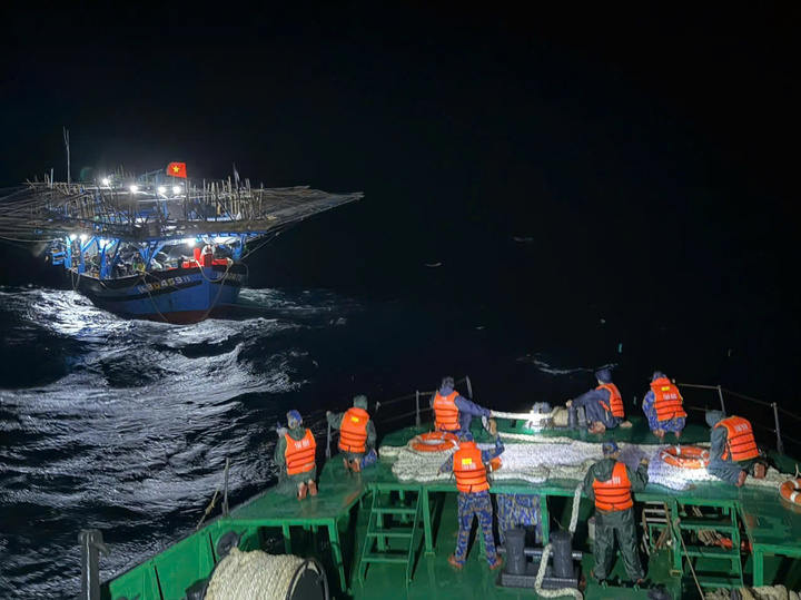 Cán bộ chiến sĩ lai dắt tàu cá về bờ.