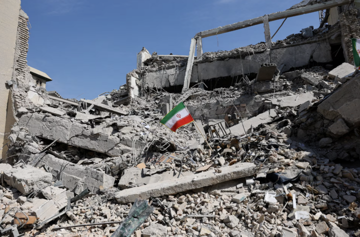 Lá cờ Iran cắm giữa đống đổ nát sau vụ không kích vào đồn cảnh sát ở Tehran.