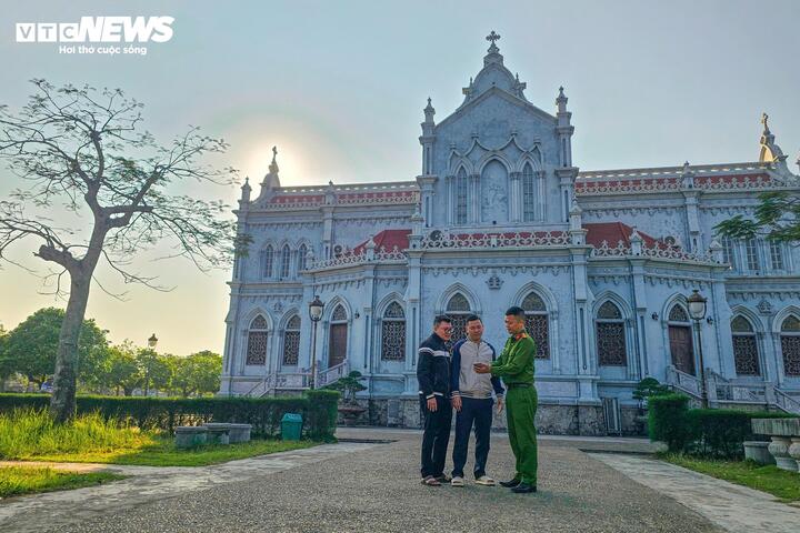 Công an xã Nghĩa Sơn gặp gỡ, tuyên truyền tới giáo dân tại khu vực nhà thờ về việc tham gia bầu cử, thực hiện quyền và nghĩa vụ công dân. (Ảnh: Minh Quang)