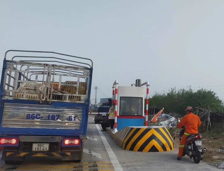 Barie trạm thu phí bị hỏng, các nhân viên dùng điện thoại chụp từng biển số xe. Ảnh: Người dân cung cấp