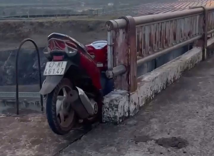 Chiếc xe máy dính trên lan can cầu.