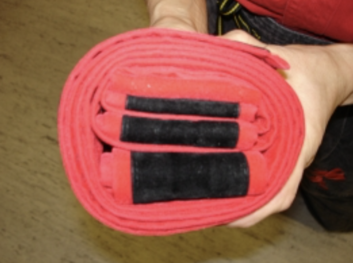 Chiếc đai đen được gấp gọn thuộc về một bậc thầy Kung Fu To'A. Ba nếp gấp với kích thước khác nhau tượng trưng cho "Suy nghĩ tốt - Lời nói tốt - Hành động tốt."