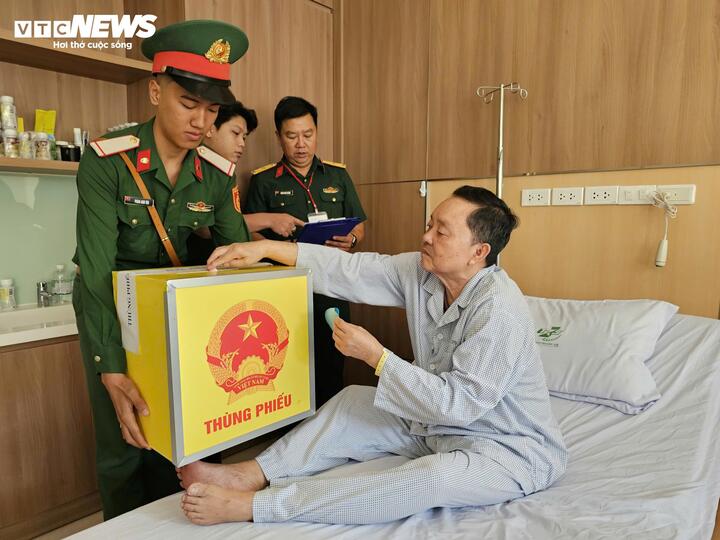 Nhân viên y tế mang thùng phiếu đến từng giường bệnh để các bệnh nhân đang điều trị nội trú bỏ phiếu bầu cử. (Ảnh: Nguyễn Liến)