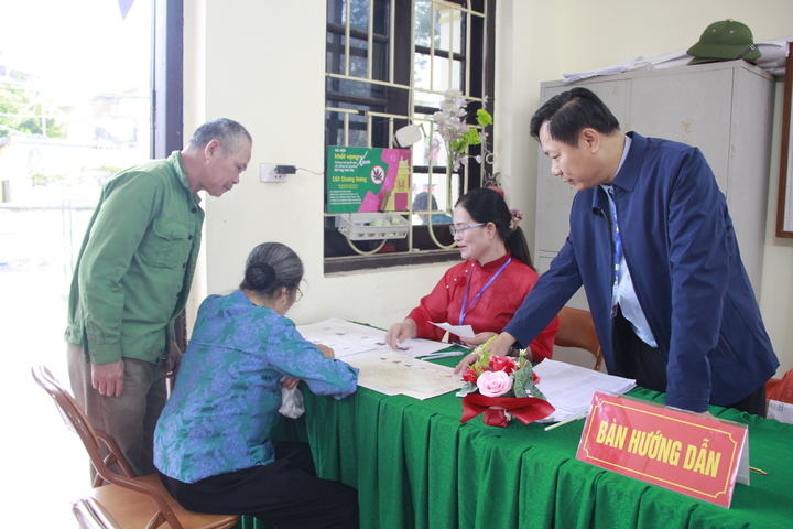 Ông Từ Ngọc Thành, Chủ tịch UBND xã Chương Dương, hướng dẫn người dân tại khu vực bỏ phiếu.