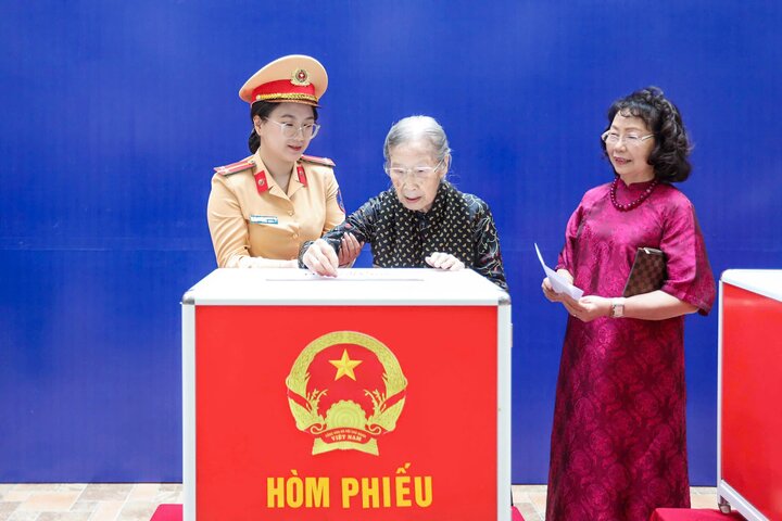 Cụ bà Đoàn Thị Thuận (101 tuổi, trú ở phường Ba Đình) được CSGT Hà Nội hỗ trợ đưa đến điểm bỏ phiếu.