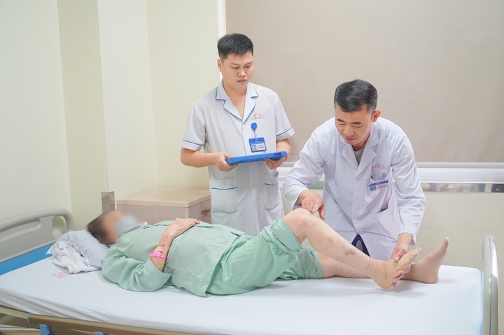 BSCKII Kiều Quốc Hiền (Trưởng khoa Phẫu thuật chấn thương chỉnh hình, Bệnh viện E) khám cho bệnh nhân trước mổ.