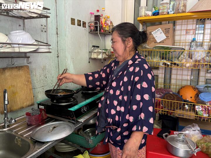 Bà Cúc nấu ăn trưa sau khi vừa từ bệnh viện về, bên hông còn đeo ống dẫn lưu.
