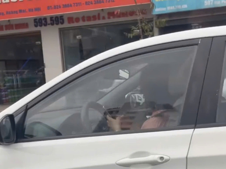 Nữ tài xế dùng điện thoại khi đang lái xe.