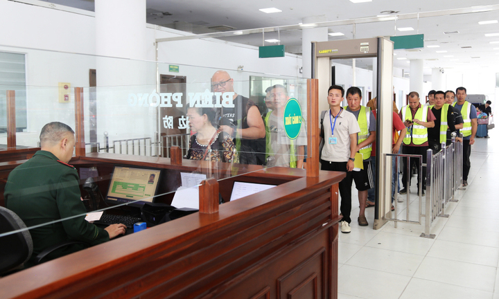 Cơ quan chức năng làm thủ tục xuất cảnh cho du khách và lái xe qua lối thông quan cầu Bắc Luân II, phường Móng Cái 1, tỉnh Quảng Ninh trong ngày 23/3. (Ảnh: Hữu Việt)