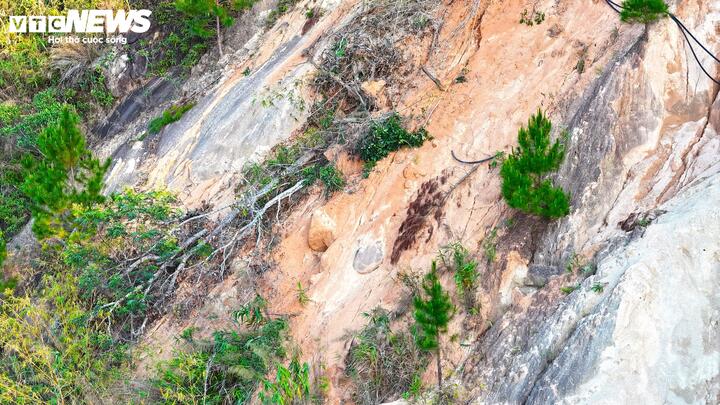 Cây cối, đất đá đổ ngã, nằm cheo leo trên sườn núi tạo cảm giác bất an cho người đi đường bên dưới.