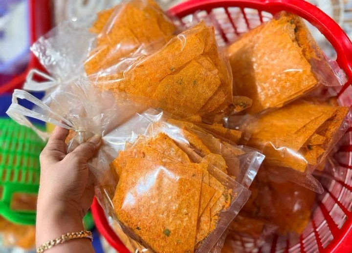 Chị Trang quyết định gom nhiều đơn hàng bánh tráng và đồ ăn vặt lại để giao một lần. (Ảnh: Đại Việt)