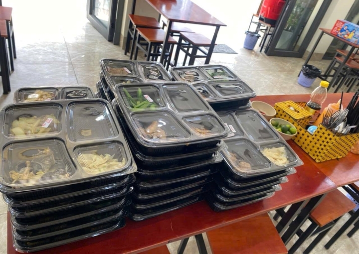 Những phần cơm trưa được chị Huyền gom đơn lại, chuẩn bị giao cho khách. (Ảnh: Đại Việt)