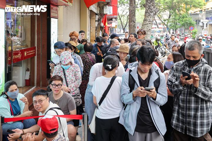Theo ghi nhận, khoảng 11h30 trưa nay, hai cửa hàng vàng Bảo Tín Minh Châu trên phố Trần Nhân Tông (phường Hai Bà Trưng) đã đông kín khách, nhiều người tập trung chờ đến giờ mở cửa để được mua - bán vàng.
