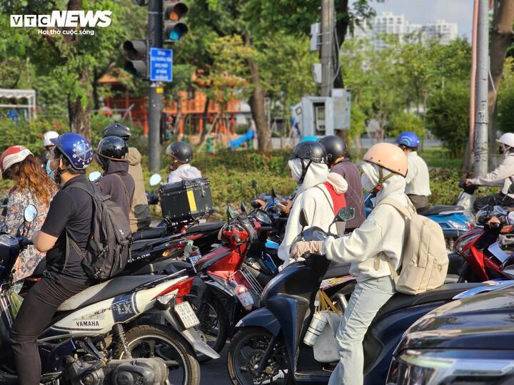Người dân TP.HCM trùm kín áo chống nắng, khẩu trang khi di chuyển dưới thời tiết oi bức từ sáng sớm.