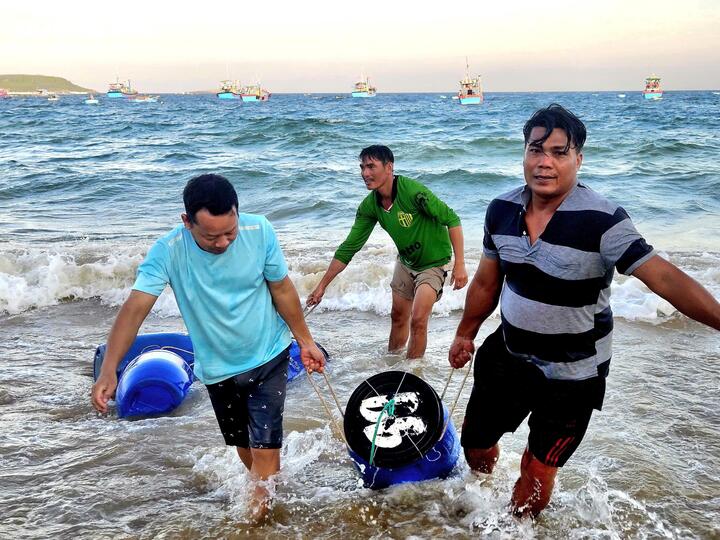 Sau khi ghe cập bờ, ngư dân sẽ đưa các phi cá lên bãi biển.