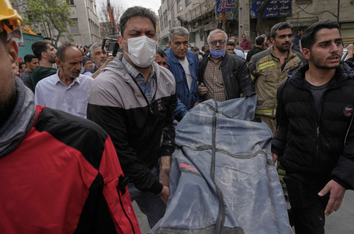 Thi thể một nạn nhân được đưa ra khỏi tòa nhà bị trúng bom trong cuộc không kích của Mỹ và Israel ở Tehran đêm 27/3. (Ảnh AP/Vahid Salemi)