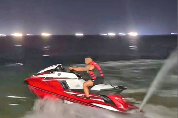 Hình ảnh cắt từ clip nam TikToker chạy mô tô nước ở bãi biển công cộng.