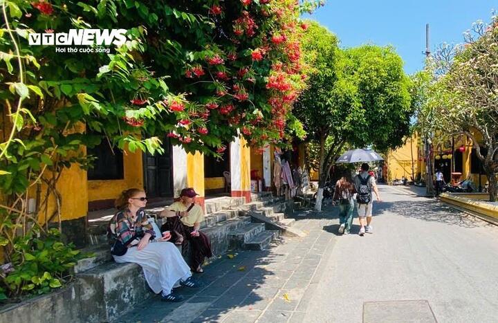 Sau khi dạo bước trên vỉa hè, 2 du khách ngồi thư giãn trên bậc thềm của một ngôi nhà cổ.