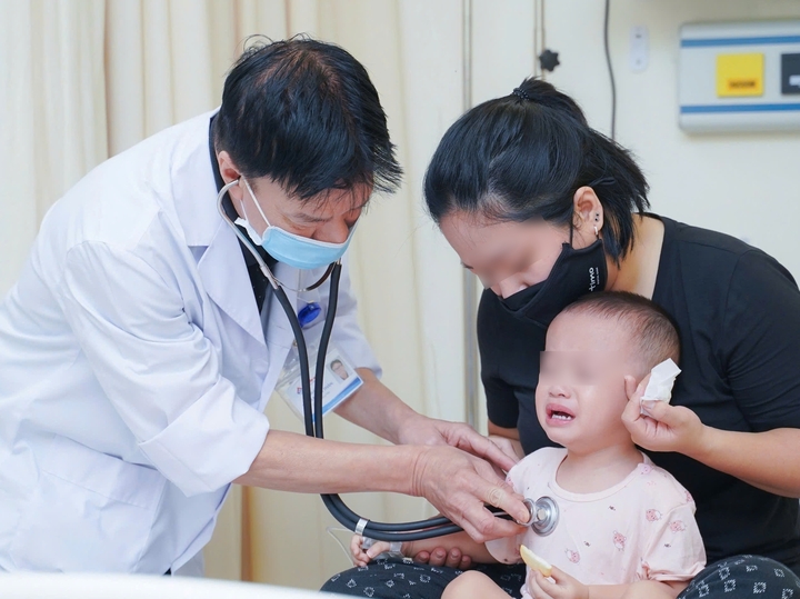 BSCKII Phạm Mạnh Thân kiểm tra sức khoẻ cho bệnh nhi. (Ảnh: Loan Hải)