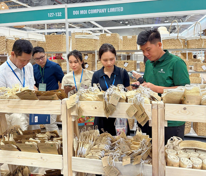 Anh Khoa (bên phải) giới thiệu sản phẩm xơ mướp tại hội chợ, từng bước đưa hàng Việt ra thị trường quốc tế.