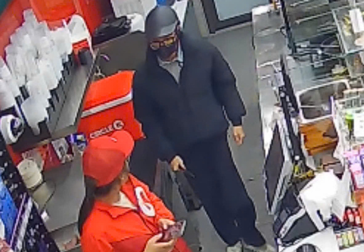 Hoàng Minh Tiến đe doạ nhân viên cửa hàng để cướp tiền.