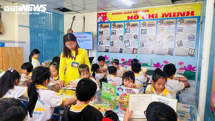 Các em học sinh hào hứng đọc sách tại thư viện.