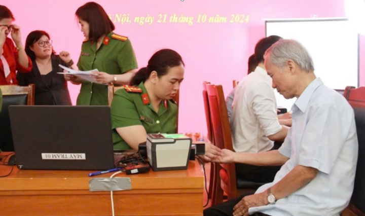 Cán bộ cảnh sát Cục QLHC về TTXH thu thập hồ sơ làm CCCD gắn chip cho người dân. (Ảnh: Cục QLHC về TTXH)