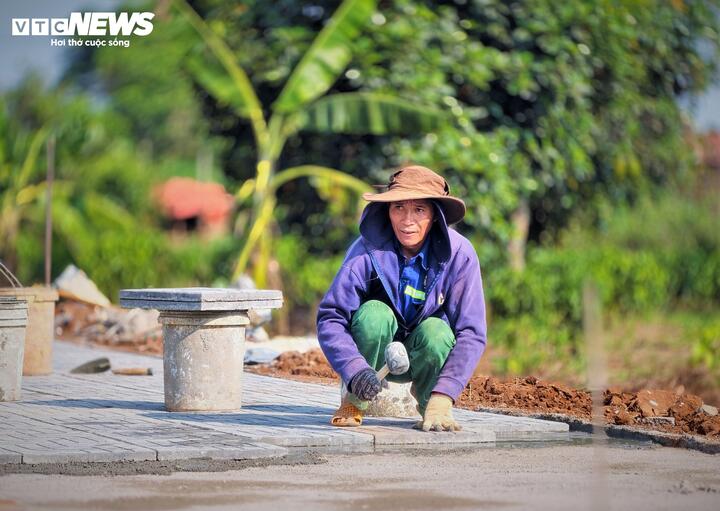 Dưới nắng gắt của vùng đất đỏ ba zan, các đơn vị thi công đang tập trung lát gạch những mét vỉa hè cuối cùng trên tuyến đường.