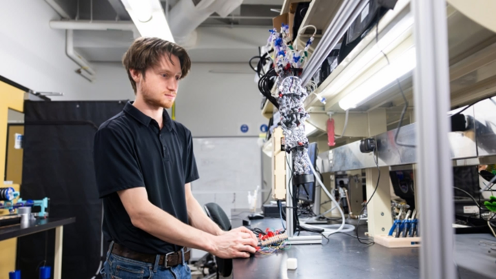 Eric Weissman, nghiên cứu sinh tiến sĩ ngành kỹ thuật cơ khí tại ASU, điều khiển một cánh tay robot được làm từ các bộ truyền động mềm. (Nguồn: Samantha Chow/ASU)