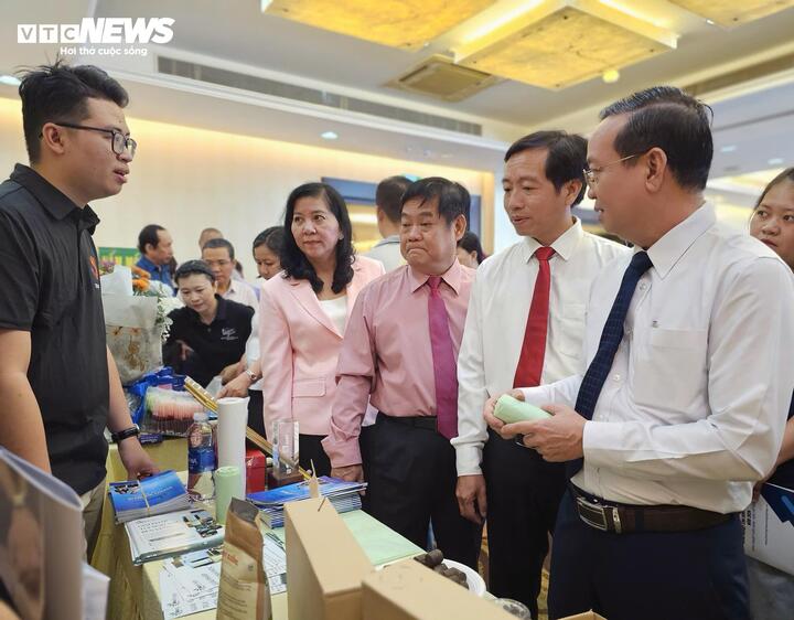 Anh Trịnh Công Qui (bên trái) chia sẻ về sáng kiến của nhóm với lãnh đạo TP.HCM tại một sự kiện về nông nghiệp công nghệ cao.
