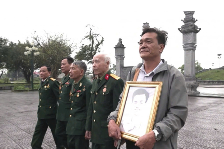 Ông Chu Đình Minh (người cầm di ảnh) vẫn mỏi mòn tìm kiếm người bố liệt sĩ hy sinh ở chiến trường Quảng Trị.