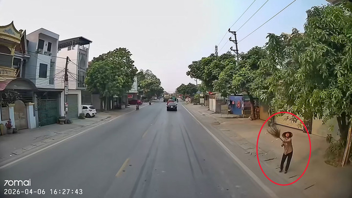 Người phụ nữ bên đường giơ chiếc chổi lên ra hiệu thì xe tải mới dừng lại.